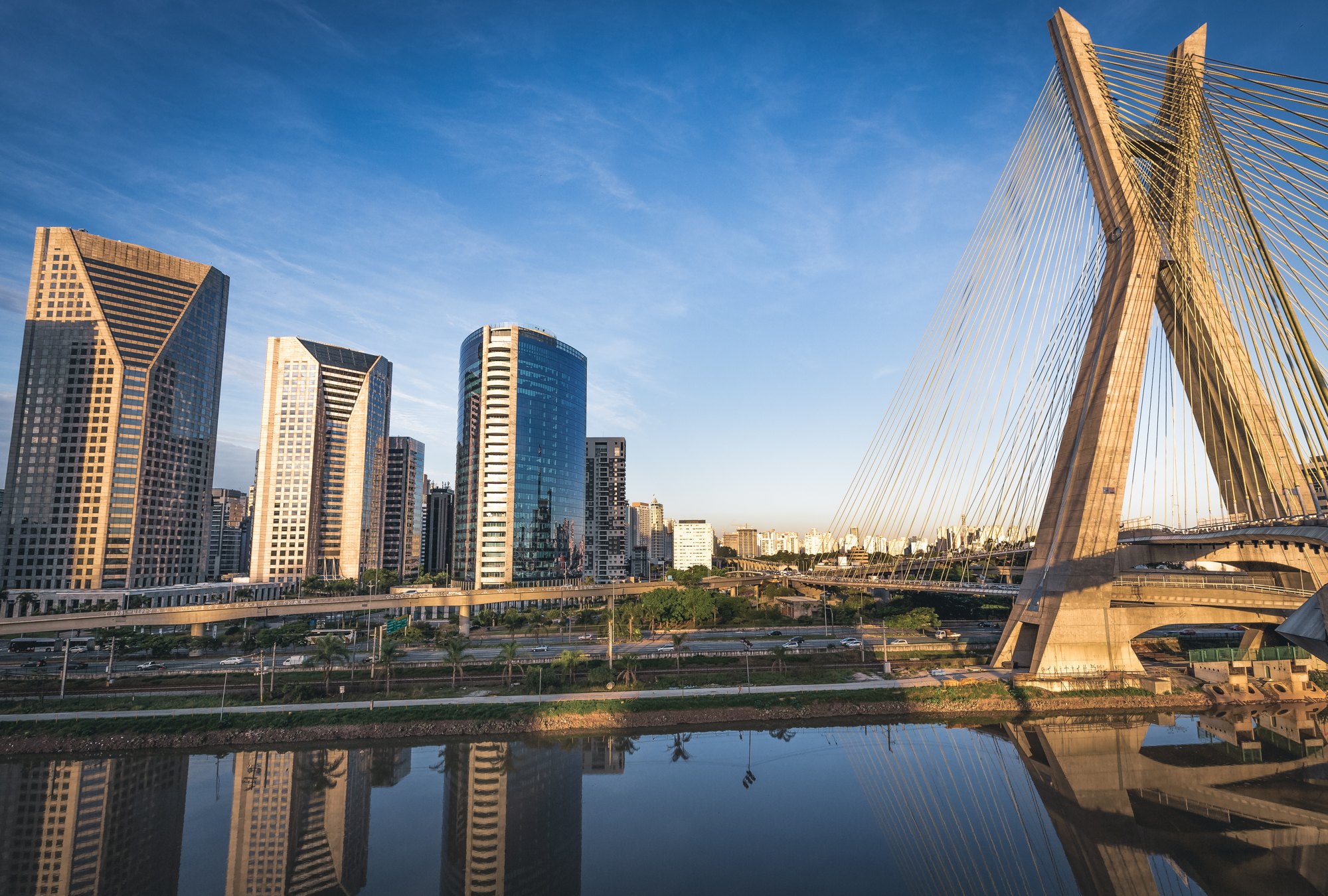 Skyline corporativo com ponte estaiada ao amanhecer